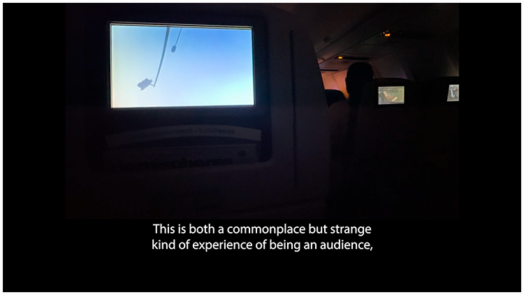 In a dark airplane, three small rectangular screens play different films. A caption with Lord's voiceover reads: This is both a commonplace but strange kind of experience of being an audience.